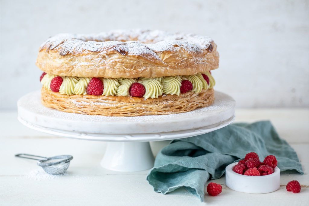 A visually exciting dessert that will have everyone gasping with delight. The combination of crisp flaked almonds, pastry cream, salty pistachio and raspberries is divine, and will leave your guests amazed you made it yourself!
