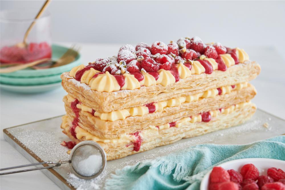This very simple but ultra-impressive showstopper Mille Feuille is the perfect centerpiece for your table.  Layers of custard and buttery puff pastry drizzled with raspberry coulis, finished with fresh berries and pistachios.